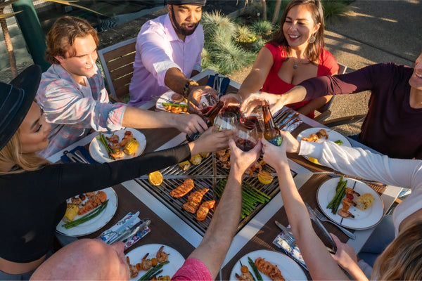 People gathered around a modern outdoor backyard grill table